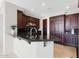 Elegant kitchen featuring dark wood cabinetry, granite countertops, and modern appliances at 15802 N 71St St # 552, Scottsdale, AZ 85254