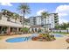 Resort-style pool area with palm trees, desert landscaping, and a multi-story building backdrop under a bright blue sky at 15802 N 71St St # 552, Scottsdale, AZ 85254