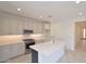 Modern kitchen with stainless steel appliances, light gray cabinetry, an island, and a white countertop at 1661 N St Francis Pl, Casa Grande, AZ 85122