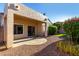 A covered patio overlooks the backyard with rock landscaping, grass and a lush garden at 16846 N 49Th Way, Scottsdale, AZ 85254