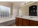 Bathroom with double vanity, large mirror, and natural light from a glass block window at 16846 N 49Th Way, Scottsdale, AZ 85254