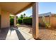 View of backyard featuring decorative rock, plants, grass and covered patio at 16846 N 49Th Way, Scottsdale, AZ 85254