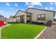 Spacious backyard with artificial turf, rock landscaping and a covered patio at 17140 W Running Deer Trl, Surprise, AZ 85387