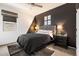 Modern bedroom featuring a gray tufted headboard, black accent wall, and stylish decor at 17140 W Running Deer Trl, Surprise, AZ 85387