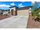 Attractive single-Gathering house boasting stone detailing, neutral stucco, and a two-car garage with a long driveway at 17140 W Running Deer Trl, Surprise, AZ 85387