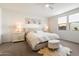 Bright main bedroom featuring a luxurious bed, soft carpet, and windows at 17140 W Running Deer Trl, Surprise, AZ 85387