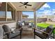 Inviting covered patio featuring comfortable seating, an outdoor fan, and view of the landscaped backyard at 17140 W Running Deer Trl, Surprise, AZ 85387