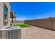 A low-maintenance backyard with gravel, a small green patch, and block wall fencing offers privacy at 1879 W 23Rd Ave, Apache Junction, AZ 85120