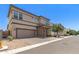 Two-story home featuring neutral stucco, brown trim, brick accents, and a two-car garage complemented by gravel landscaping at 1879 W 23Rd Ave, Apache Junction, AZ 85120