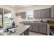 Modern kitchen featuring granite countertops, stainless appliances, gray cabinets, and natural light at 1879 W 23Rd Ave, Apache Junction, AZ 85120