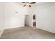 Bright bedroom with neutral carpet, ceiling fan, and an open doorway to ensuite bathroom at 18805 N 49Th Dr, Glendale, AZ 85308