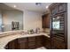 Interior bar area featuring dark wood cabinetry, wine refrigerator, and granite countertops at 22020 N Church Rd, Scottsdale, AZ 85255