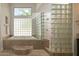Bright bathroom with glass block accents, soaking tub and walk-in shower at 22020 N Church Rd, Scottsdale, AZ 85255