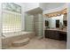 Bathroom featuring soaking tub with a glass block shower wall at 22020 N Church Rd, Scottsdale, AZ 85255