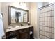 Elegant bathroom featuring a marble vanity, framed mirror, and shower with neutral-toned tiling at 22020 N Church Rd, Scottsdale, AZ 85255