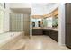 Bright bathroom featuring a separate tub, glass-blocked shower, and vanity area at 22020 N Church Rd, Scottsdale, AZ 85255