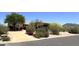 Stunning home featuring lush desert landscaping, mature trees, colorful bushes, and a circular driveway at 22020 N Church Rd, Scottsdale, AZ 85255
