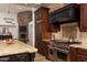 Up close look at high-end kitchen with custom cabinetry, stainless steel Wolf range, and stone accent wall at 22020 N Church Rd, Scottsdale, AZ 85255