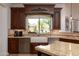 Charming kitchen details include granite countertops, stainless steel appliances, and a farmhouse sink with backyard views at 22020 N Church Rd, Scottsdale, AZ 85255