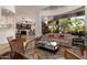 Living room with large window overlooking the pool area, open to kitchen with bar seating at 22020 N Church Rd, Scottsdale, AZ 85255