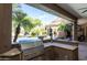 Fully equipped outdoor kitchen with stainless steel grill, granite countertops, and a view of the pool at 22020 N Church Rd, Scottsdale, AZ 85255