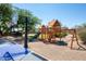Backyard wooden playset, swing, slide and basketball hoop offer a fun-filled entertainment area for children at 22020 N Church Rd, Scottsdale, AZ 85255