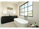 Elegant bathroom showcases a freestanding tub, stylish vanity, and a large picture window at 2315 E Mine Creek Rd, Phoenix, AZ 85024