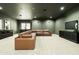 Living room featuring a huge leather sectional couch, custom cabinets, and a large screen television at 2315 E Mine Creek Rd, Phoenix, AZ 85024