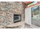 Inviting stone fireplace with a full view glass door, opening onto the pool patio at 2326 E Gardenia Dr, Phoenix, AZ 85020