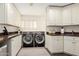 Functional laundry room boasts ample cabinet space, countertops, and front load washer/dryer at 2326 E Gardenia Dr, Phoenix, AZ 85020