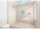 Modern bathroom featuring a glass-enclosed shower with neutral stone tile and updated fixtures at 2326 E Gardenia Dr, Phoenix, AZ 85020