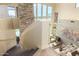 Modern staircase design with stone accents, glass railing, and a view into the living room, adding a touch of elegance at 2326 E Gardenia Dr, Phoenix, AZ 85020