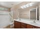 Well-lit bathroom featuring double sinks, wooden cabinetry, and a shower-tub combination at 2487 S Conestoga Rd, Apache Junction, AZ 85119