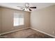 A clean bedroom space with carpet flooring, a ceiling fan, and natural light from the window at 2487 S Conestoga Rd, Apache Junction, AZ 85119