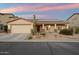 Charming single-story home featuring desert landscaping, a two-car garage, and solar panels on the roof at 2487 S Conestoga Rd, Apache Junction, AZ 85119