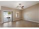 Bright, empty room featuring tile flooring, a ceiling fan, a sliding glass door, and a single window at 2487 S Conestoga Rd, Apache Junction, AZ 85119