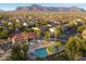 Aerial shot showcasing a community pool area with palm trees, umbrellas, and mountain views at 2487 S Conestoga Rd, Apache Junction, AZ 85119