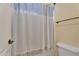 Bathroom featuring a toilet, shower and tub with a white and blue lace shower curtain at 24886 W Huntington Dr, Buckeye, AZ 85326