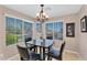 Bright dining area with large windows, contemporary chandelier, and comfortable seating for Gathering meals at 24886 W Huntington Dr, Buckeye, AZ 85326