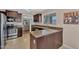 Eat-in kitchen with breakfast bar, stainless steel appliances, and an open layout to the living area at 24886 W Huntington Dr, Buckeye, AZ 85326