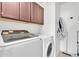 Functional laundry area with washer, dryer, upper cabinets, and ample storage space at 24886 W Huntington Dr, Buckeye, AZ 85326