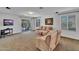 Cozy living room with a neutral color palette, carpet flooring, and sliding glass doors leading to the patio at 24886 W Huntington Dr, Buckeye, AZ 85326