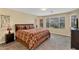 Comfortable main bedroom with a patterned bedspread, dresser, and view of natural light through the window at 24886 W Huntington Dr, Buckeye, AZ 85326