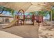 Well-maintained playground with various play structures and a shaded canopy for sunny days at 24886 W Huntington Dr, Buckeye, AZ 85326