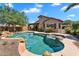 Backyard with a lagoon-style pool, spa, rock features, and lush landscaping at 24886 W Huntington Dr, Buckeye, AZ 85326