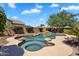 Backyard featuring a lagoon-style pool, spa, rock features, and mature landscaping at 24886 W Huntington Dr, Buckeye, AZ 85326