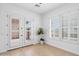 White bedroom with wood-look floors, double doors to balcony, and bright windows at 2722 W Hiddenview Dr, Phoenix, AZ 85045