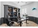 Stylish home office with built-in bookshelves and a sleek, adjustable desk at 2722 W Hiddenview Dr, Phoenix, AZ 85045