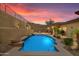 Beautiful pool area with desert plants and lighting on a desert hillside under a colorful sunset at 2722 W Hiddenview Dr, Phoenix, AZ 85045