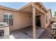 Covered back patio with an outdoor dining area, string lights, and access to the backyard at 2813 N 107Th Dr, Avondale, AZ 85392